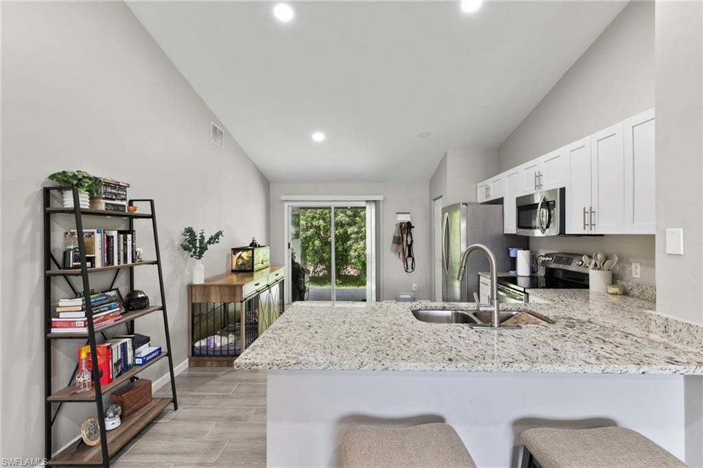 8264-8268 Matanzas Road Fort Myers, FL 33967 - Photo 6 of 33 a kitchen with stainless steel appliances granite countertop a sink and a refrigerator