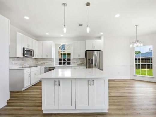 5034 West Fall Drive Midlothian, TX 76065 - Photo 14 of 40 Kitchen featuring a large central island with white cabinetry, stainless steel appliances, and wood-finish flooring