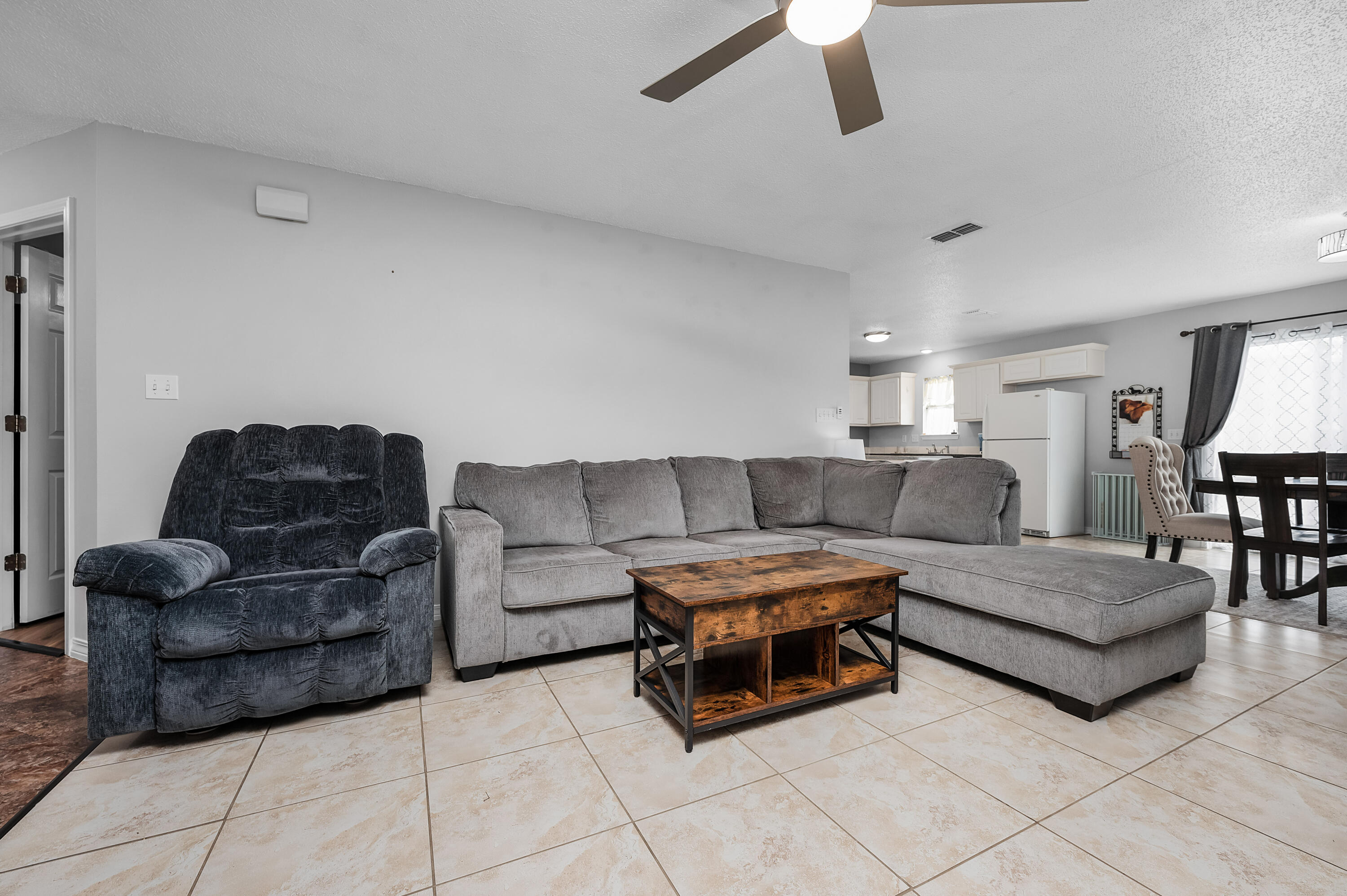 281 Limestone Circle Crestview, FL 32539 - Photo 11 of 46 a living room with couches and a dining table with wooden floor