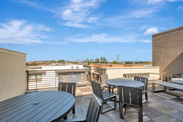 a view of a roof deck with table and chairs