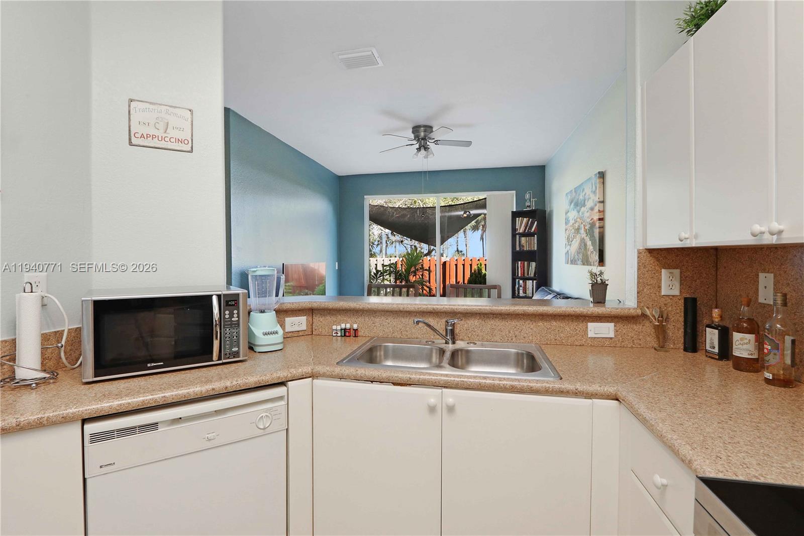 14973 Southwest 8th Terrace Miami, FL 33194 - Photo 10 of 32 a kitchen with stainless steel appliances granite countertop a sink and a white cabinets