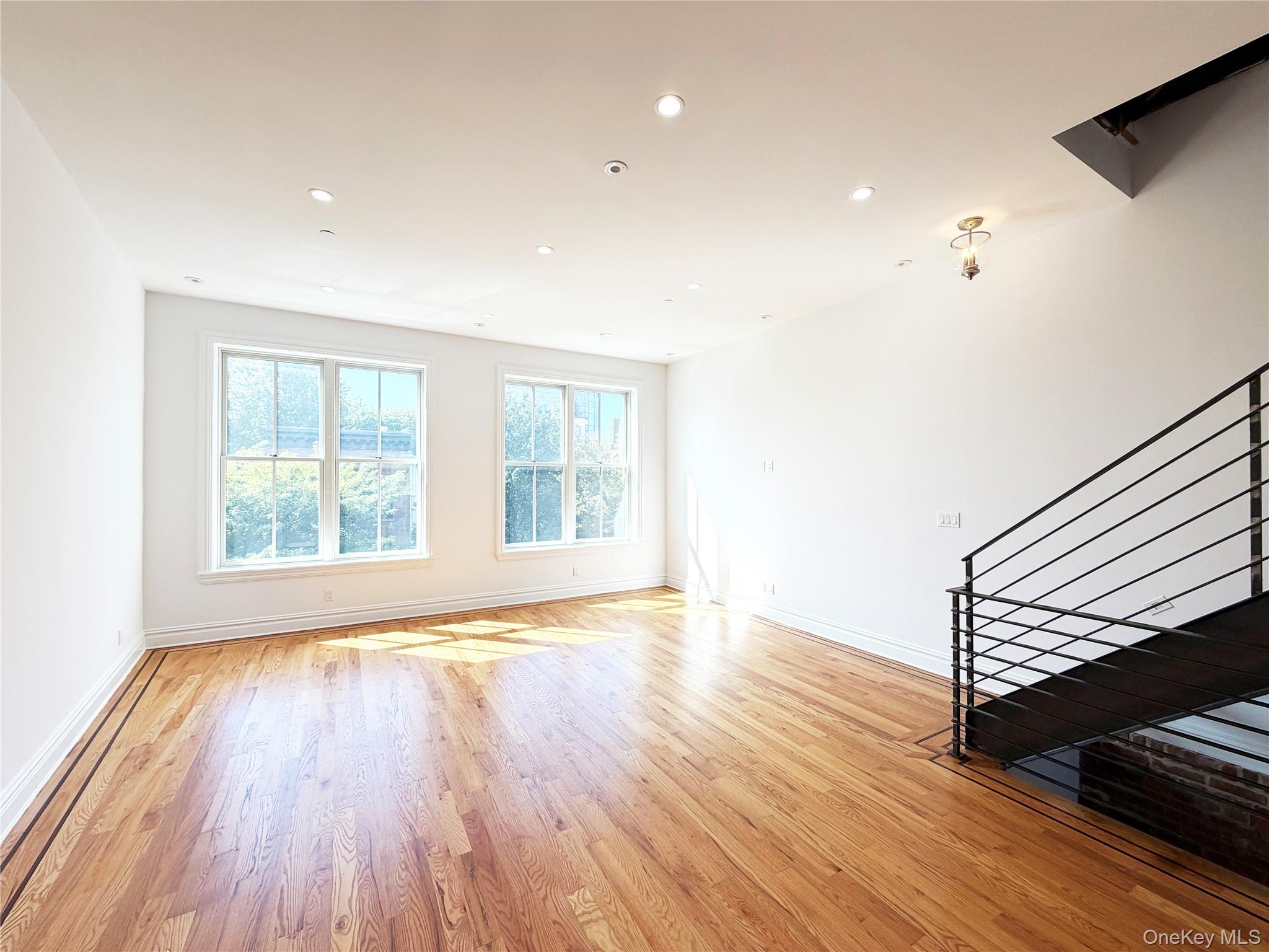 333 Tompkins Avenue, Unit PH2 Brooklyn, NY 11216 - Photo 12 of 33 an empty room with wooden floor and windows