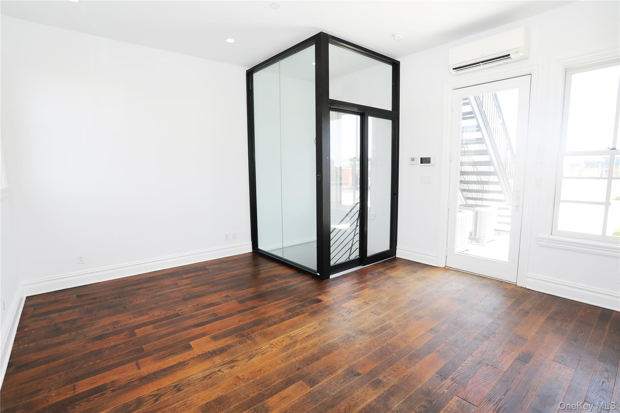 333 Tompkins Avenue, Unit PH2 Brooklyn, NY 11216 - Photo 30 of 33 an empty room with wooden floor and windows