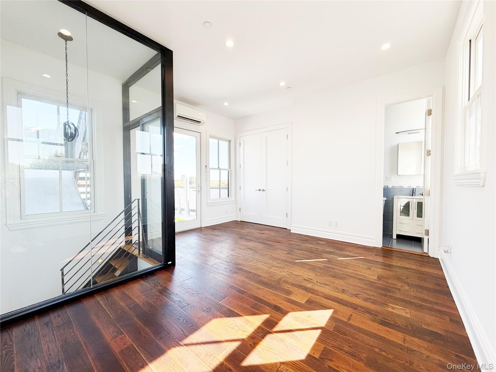 333 Tompkins Avenue, Unit PH2 Brooklyn, NY 11216 - Photo 31 of 33 a view of empty room with wooden floor and windows