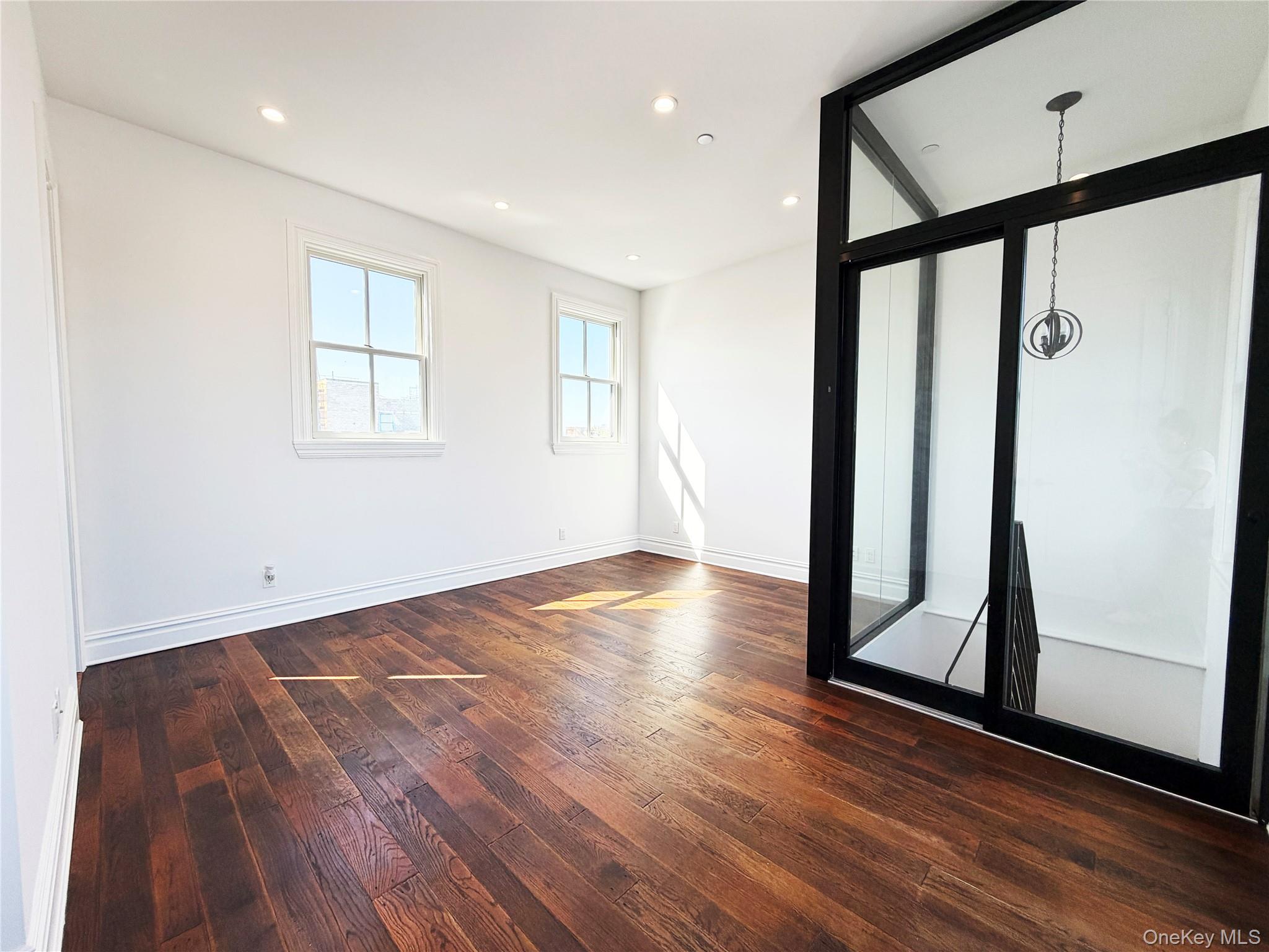 333 Tompkins Avenue, Unit PH2 Brooklyn, NY 11216 - Photo 32 of 33 a view of an empty room with wooden floor and a window