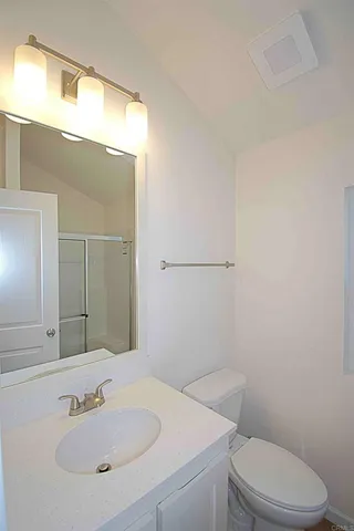 a bathroom with a sink a toilet and mirror