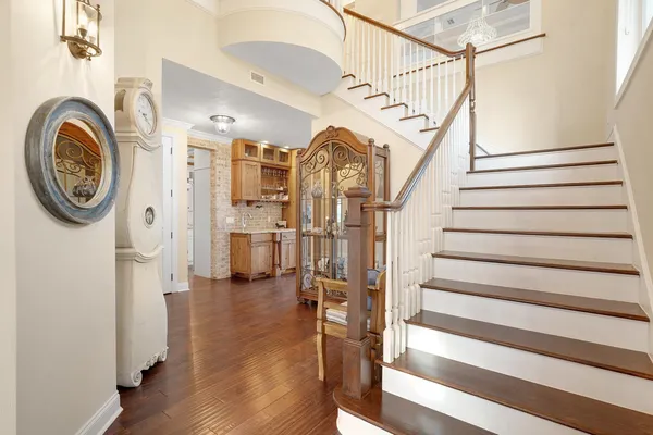 a view of a hallway with wooden floor and staircase