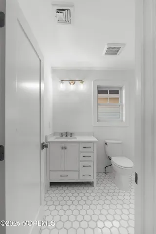 a bathroom with a granite countertop toilet sink and mirror