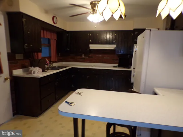 a bathroom with a sink a large mirror and a refrigerator