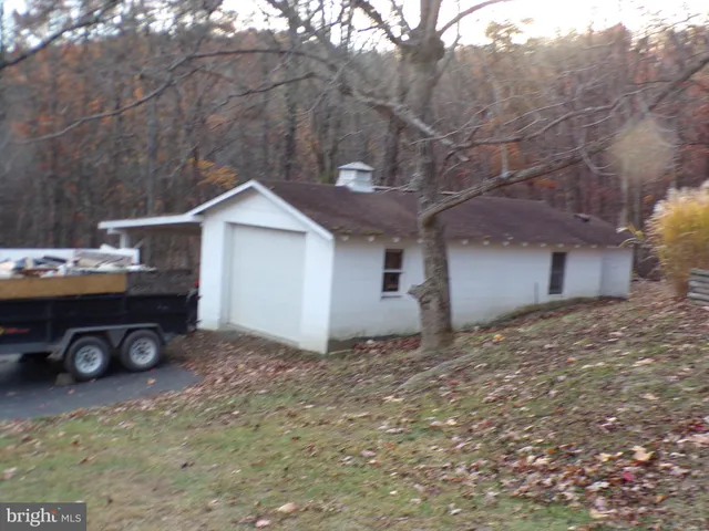 a view of a house with backyard and a tree