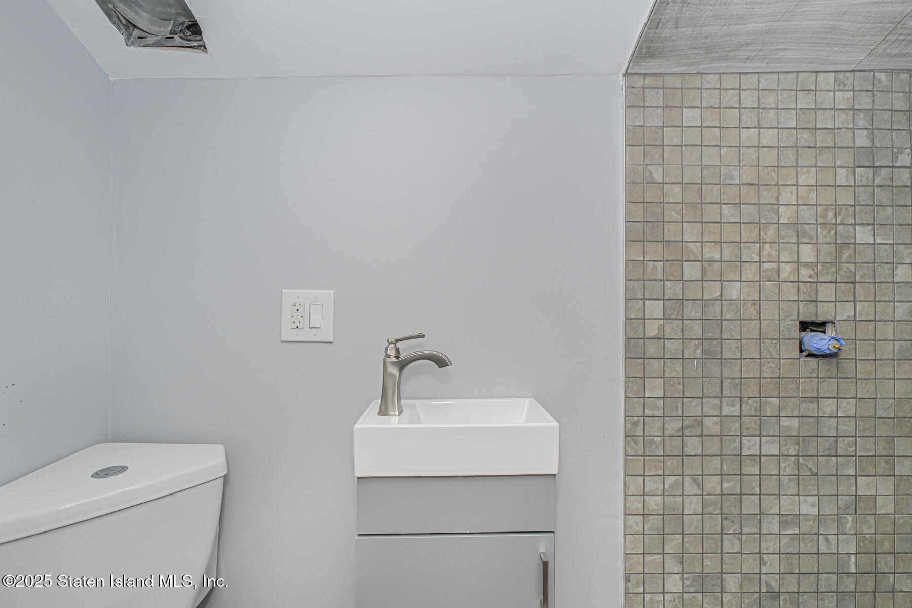 71 Sands Street Staten Island, NY 10304 - Photo 20 of 35 a bathroom with a toilet a sink and mirror