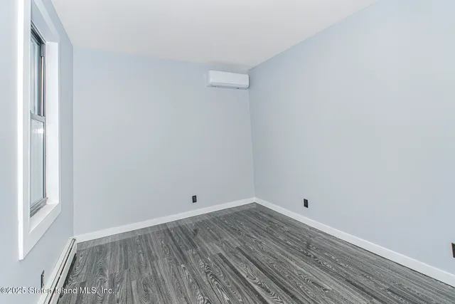 a view of a room with wooden floor and window