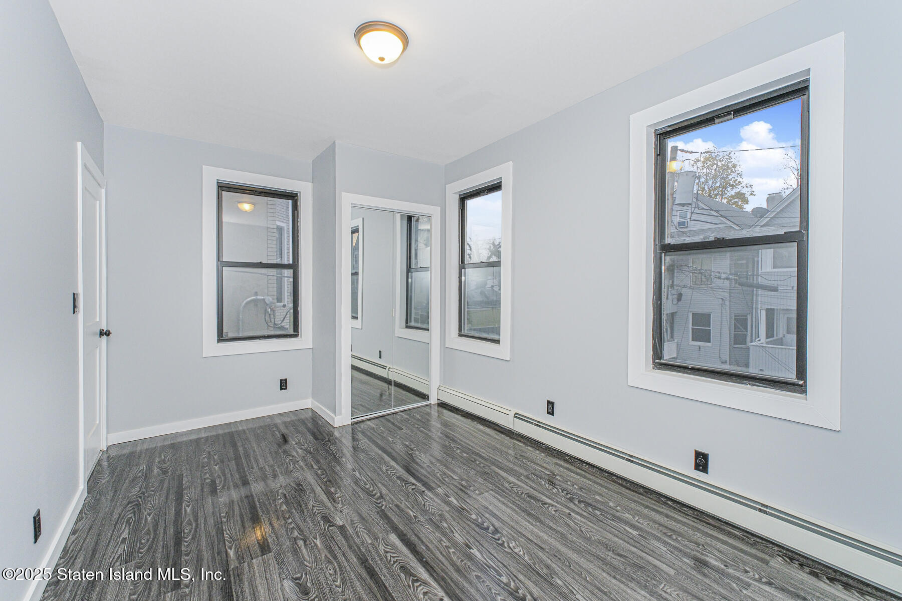 71 Sands Street Staten Island, NY 10304 - Photo 7 of 35 a view of an empty room with wooden floor and a window