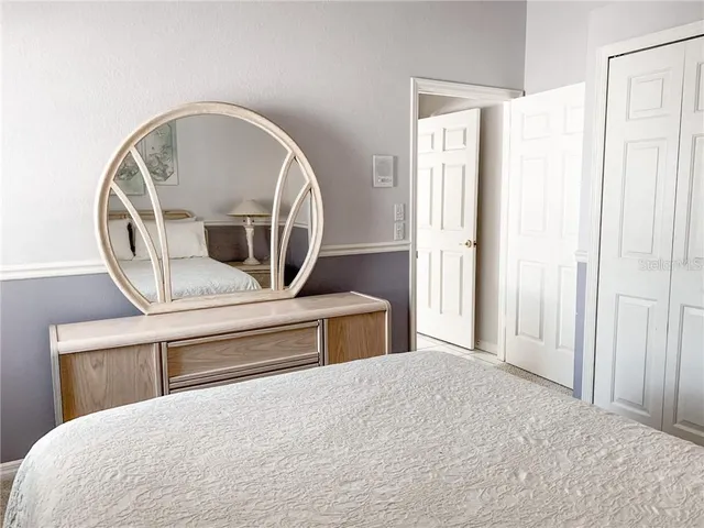 a bedroom with a bed and a mirror