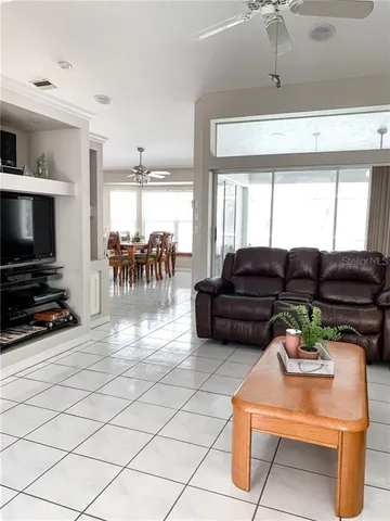a living room with furniture a flat screen tv and a window