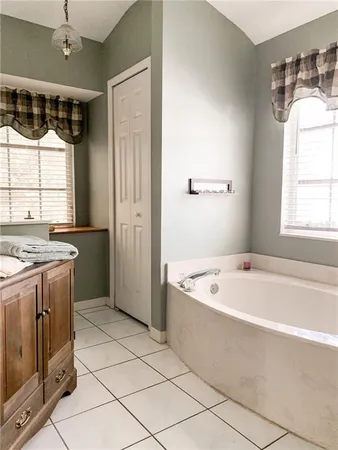 a bathroom with a tub a sink and a window