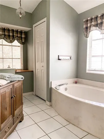 a bathroom with a tub a sink and a window