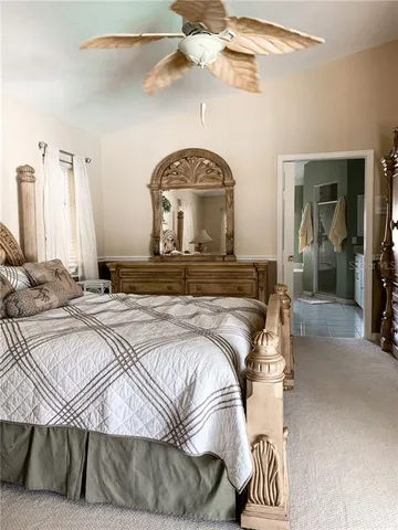 a view of a bedroom with a bed and ceiling fan