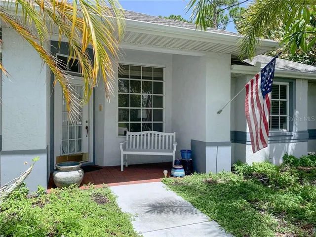 a view of a house with a small yard and wooden fence
