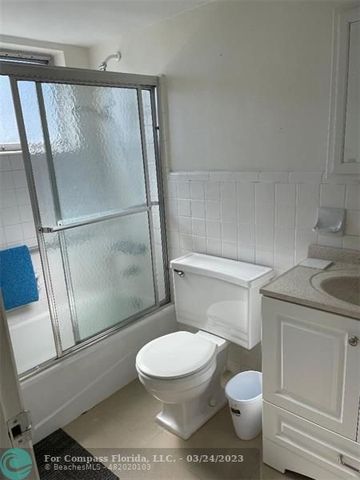 a white toilet sitting next to a tub