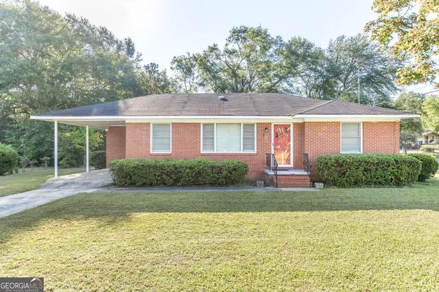 a view of a house with a yard and potted plants