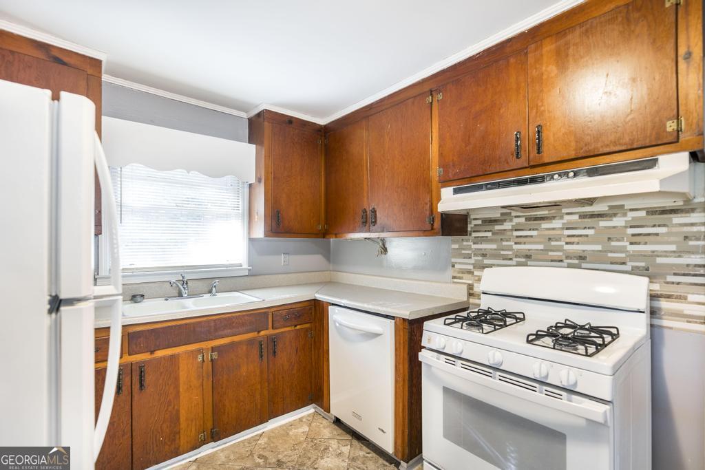 103 Thomas Street Dublin, GA 31021 - Photo 14 of 24 a kitchen with a stove a sink and a microwave