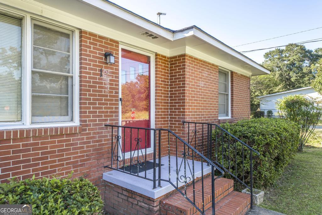 103 Thomas Street Dublin, GA 31021 - Photo 3 of 24 a view of a house with a small deck and a chair