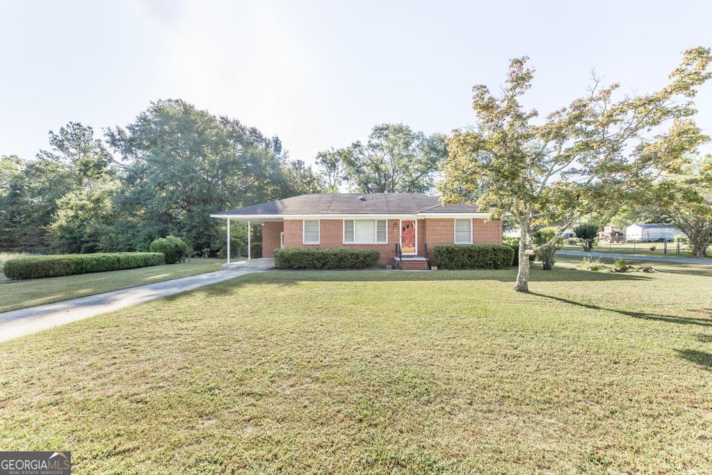 103 Thomas Street Dublin, GA 31021 - Photo 9 of 24 a swimming pool with outdoor seating and yard