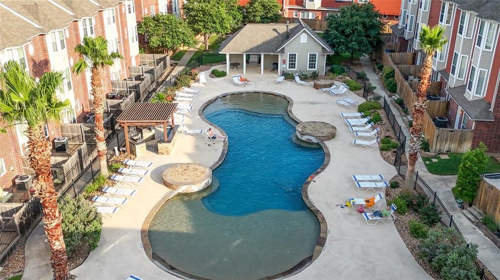 1198 Jones-Butler Road, Unit MULTI College Station, TX 77840 - Photo 17 of 36 Resort-style pool surrounded by lounge chairs, palm trees, and shaded seating areas.