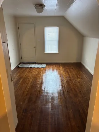 a view of a room with wooden floor and window
