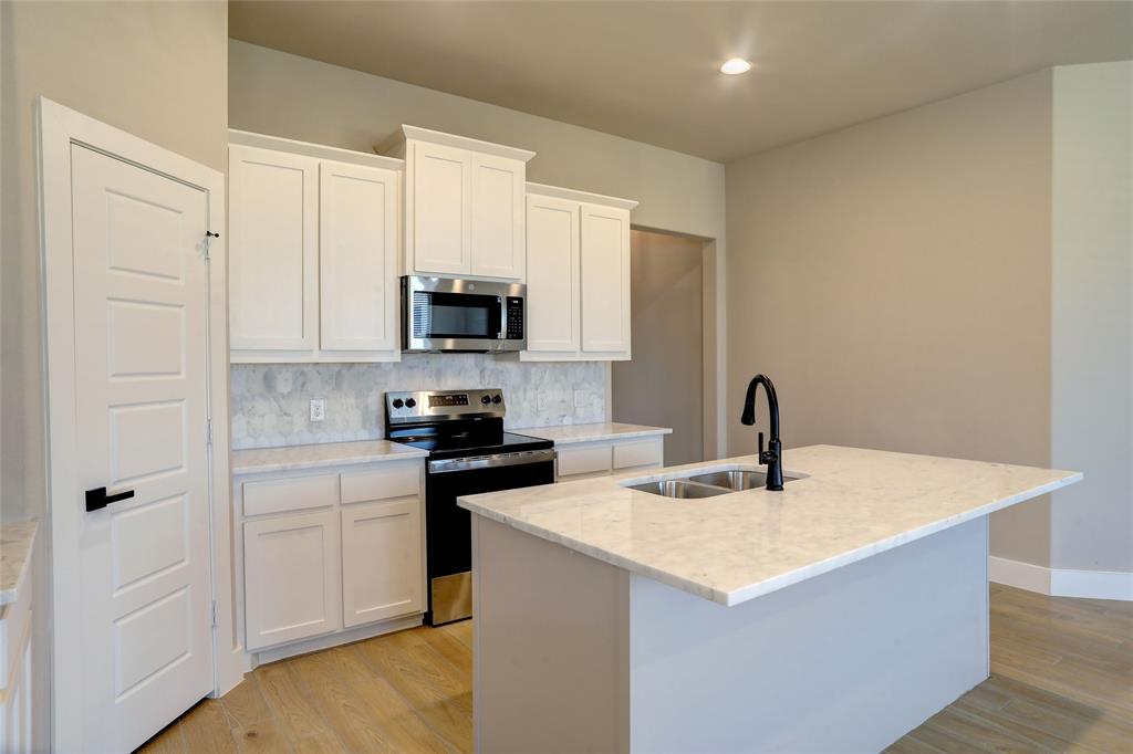 204 Pennington Road Josephine, TX 75173 - Photo 8 of 25 a kitchen with stainless steel appliances granite countertop a sink a stove a microwave a counter space and cabinets