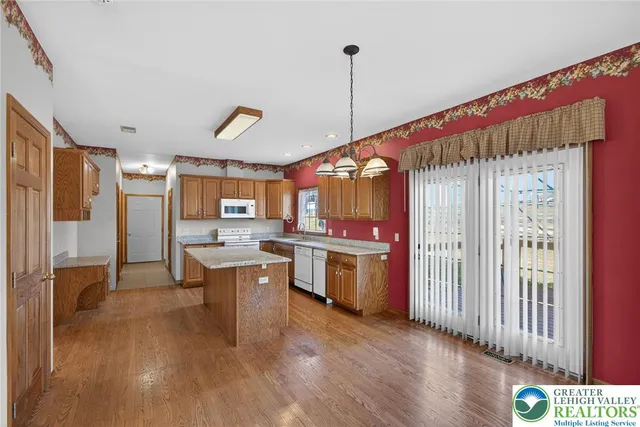 a kitchen with stainless steel appliances granite countertop a sink a microwave oven and a dining table with wooden floor