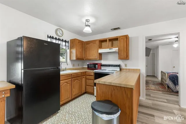 a kitchen with a table chairs cabinets and wooden floor