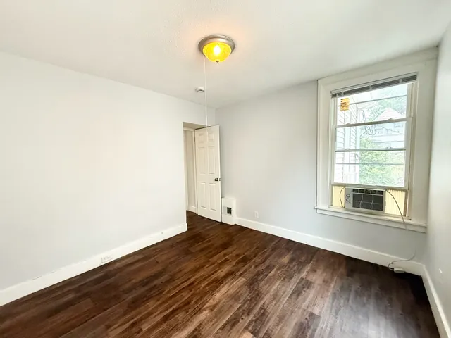 a view of a room with wooden floor and window