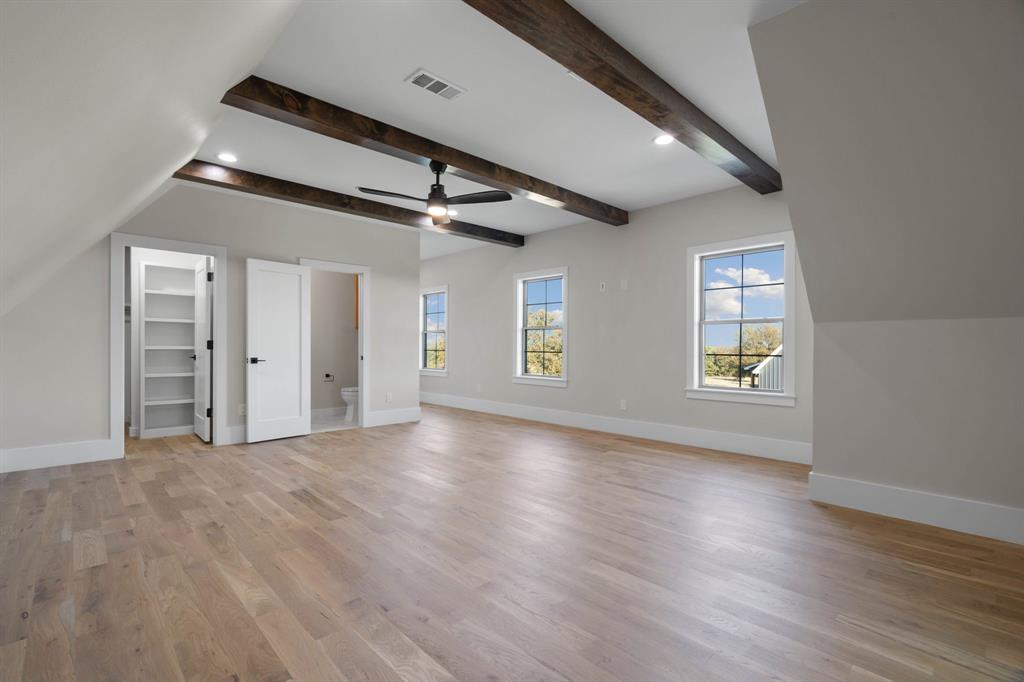 559 Aermotor Loop Weatherford, TX 76085 - Photo 14 of 39 an empty room with wooden floor chandelier and windows