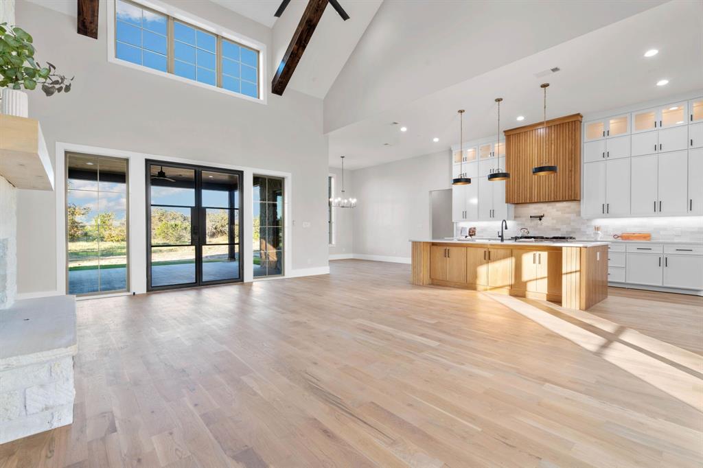559 Aermotor Loop Weatherford, TX 76085 - Photo 7 of 39 a view of a kitchen with kitchen island a refrigerator wooden floor and a large window