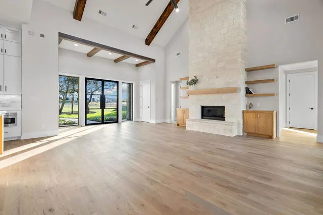 an empty room with windows and fireplace