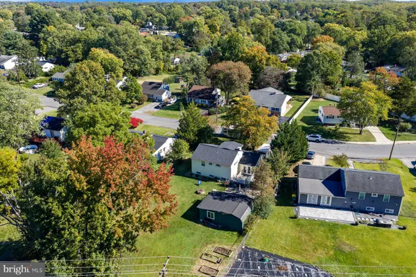 an aerial view of residential houses with outdoor space and trees all around