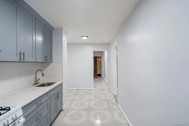 a hallway with a sink and cabinets