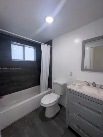 a bathroom with a sink a toilet a mirror and bathtub