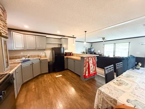 a kitchen with stainless steel appliances kitchen island granite countertop a refrigerator and stove
