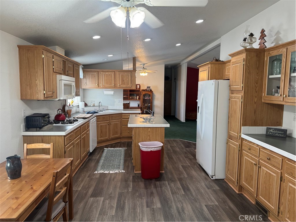 39 Spruce Via Anaheim, CA 92801 - Photo 7 of 10 a kitchen with a refrigerator a sink dishwasher and white cabinets with wooden floor