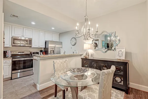 a kitchen with microwave a stove and chairs