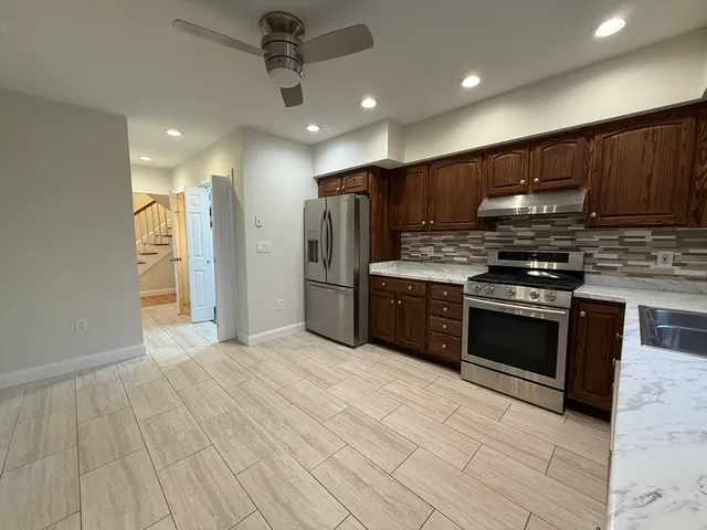 a kitchen with stainless steel appliances granite countertop a stove and a refrigerator