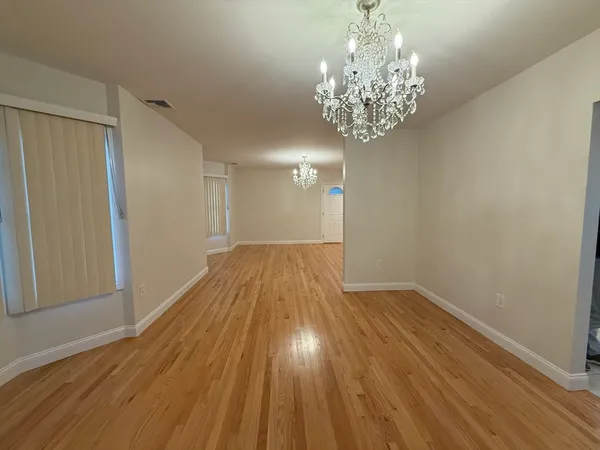 a view of wooden floor and chandelier in a room