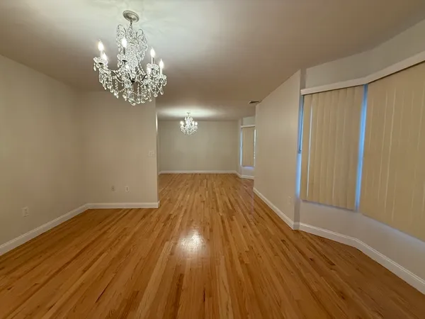 a view of a room with wooden floor and a hallway
