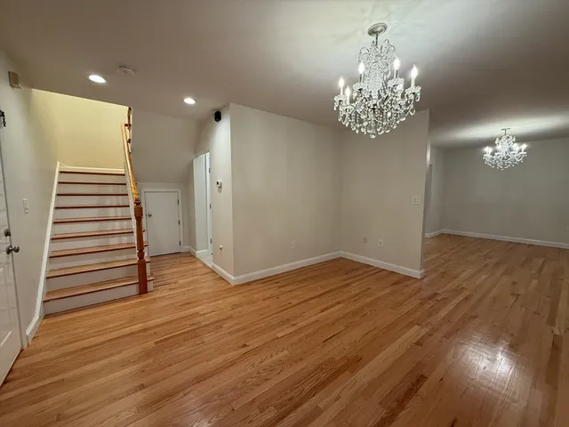 wooden floor in an empty room with a chandelier