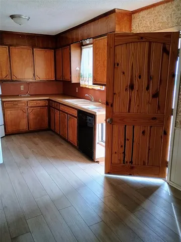 a kitchen with stainless steel appliances granite countertop a stove a sink dishwasher and a microwave oven with wooden floor
