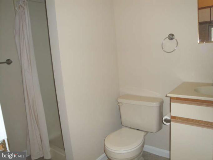 9702 Harford Road Baltimore, MD 21234 - Photo 8 of 17 a white toilet sitting next to a shower