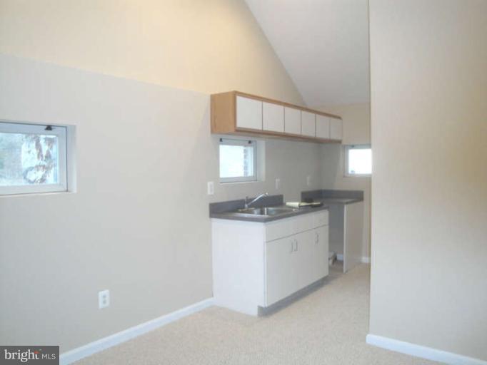 9702 Harford Road Baltimore, MD 21234 - Photo 10 of 17 a kitchen with a sink a stove and cabinets